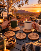 Engraved timber coasters with enamel mugs at an outback campsite at sunset